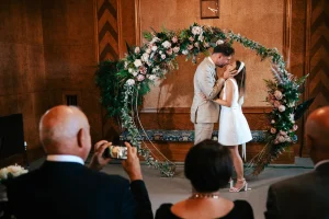 The first kiss photographed by the Town Hall Walthamstow photographer capturing a couple's first kiss as newlyweds, Fellowship Square, Waltham Forest Town Hall in London