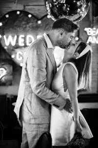 Loving Couple surrounded by glowing vintage neon signs and Hollywood props at Gods Own Junkyard, Walthamstow