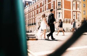 Newlyweds walking hand in hand along street after their the old marylebone town hall wedding.
