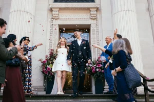 Beautiful shot of Newlyweds surrounded by confetti outside Old Marylebone Town Hall in London.
