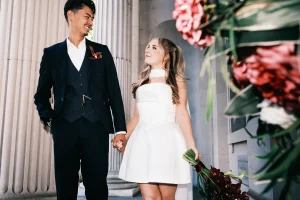 Couple walking hand in hand on the steps of Marylebone Town Hall after their wedding.